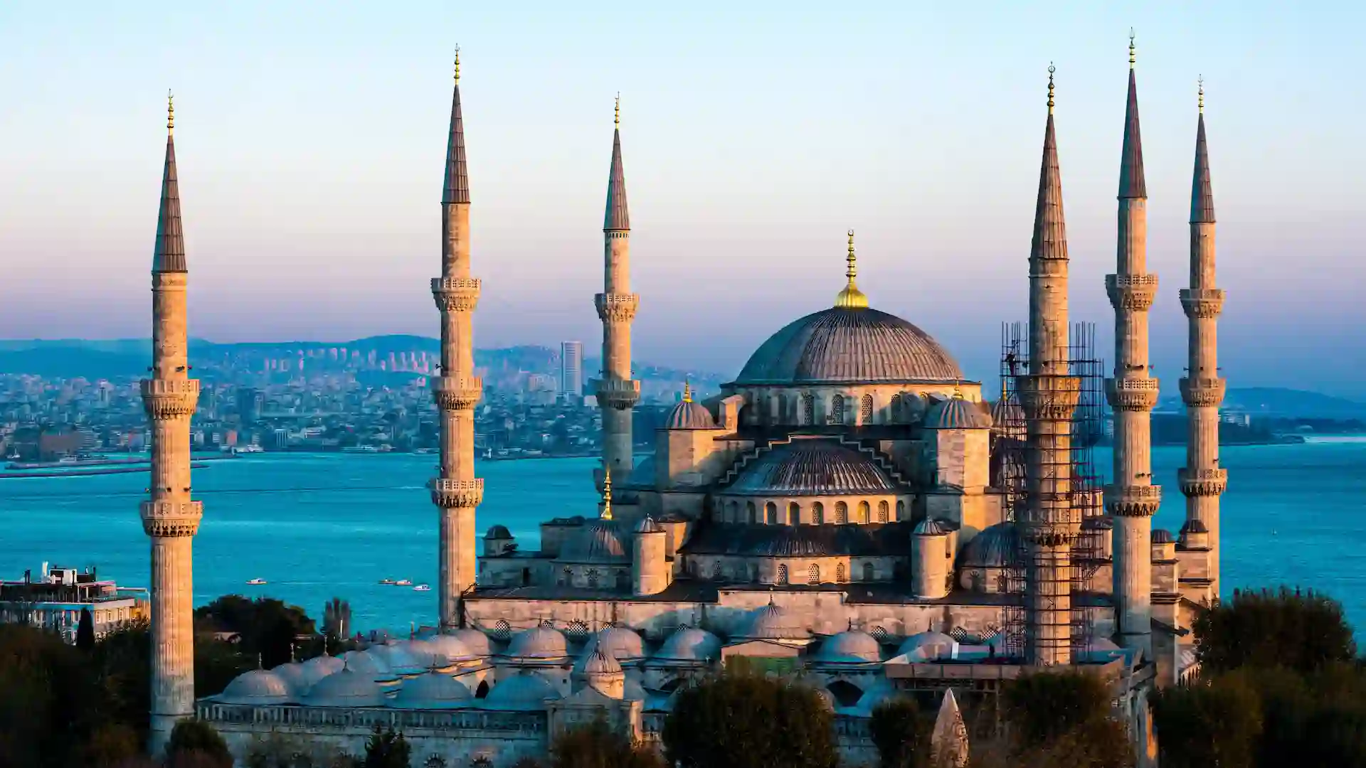 The Blue Mosque, or Sultan Ahmed Mosque, is famous for its six minarets and striking blue Iznik tiles. The interior is adorned with intricate calligraphy and stained glass, creating a serene atmosphere. It remains an active place of worship, inviting visitors to experience its spiritual ambiance. The mosque is set against a backdrop of beautiful gardens.